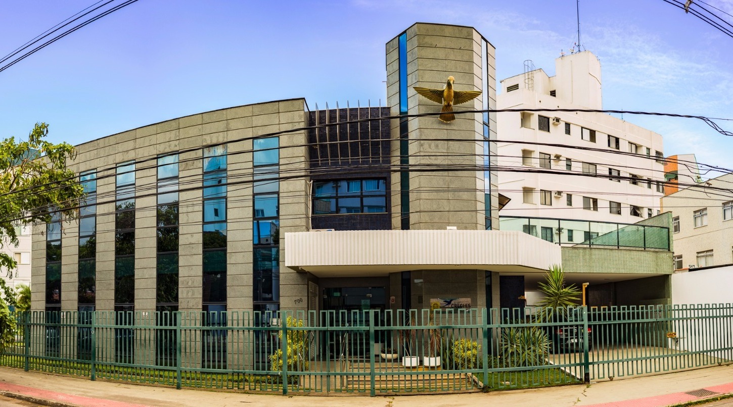 fachada do prédio do Conselho Regional de Corretores de Imóveis do Espírito Santo com grades verdes e céu azul ao fundo