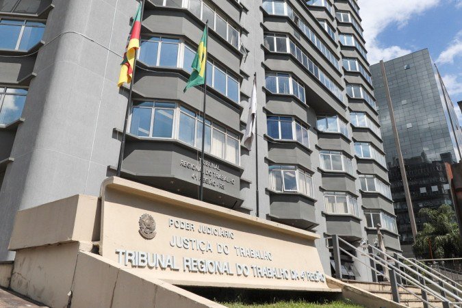 fachada do prédio do Tribunal Regional do Trabalho da 4ª Região com bandeiras e placa do órgão