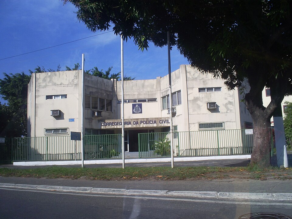 prédio da Corregedoria da Polícia Civil da Bahia com portão verde e céu azul